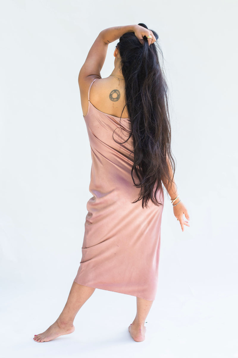 back of model wearing silk midi dress in muted pink