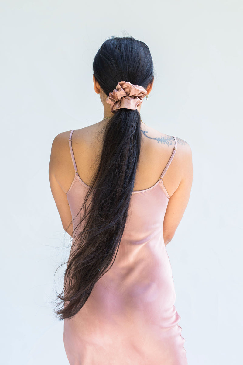model wearing muted rose pink silk scrunchie in ponytail 