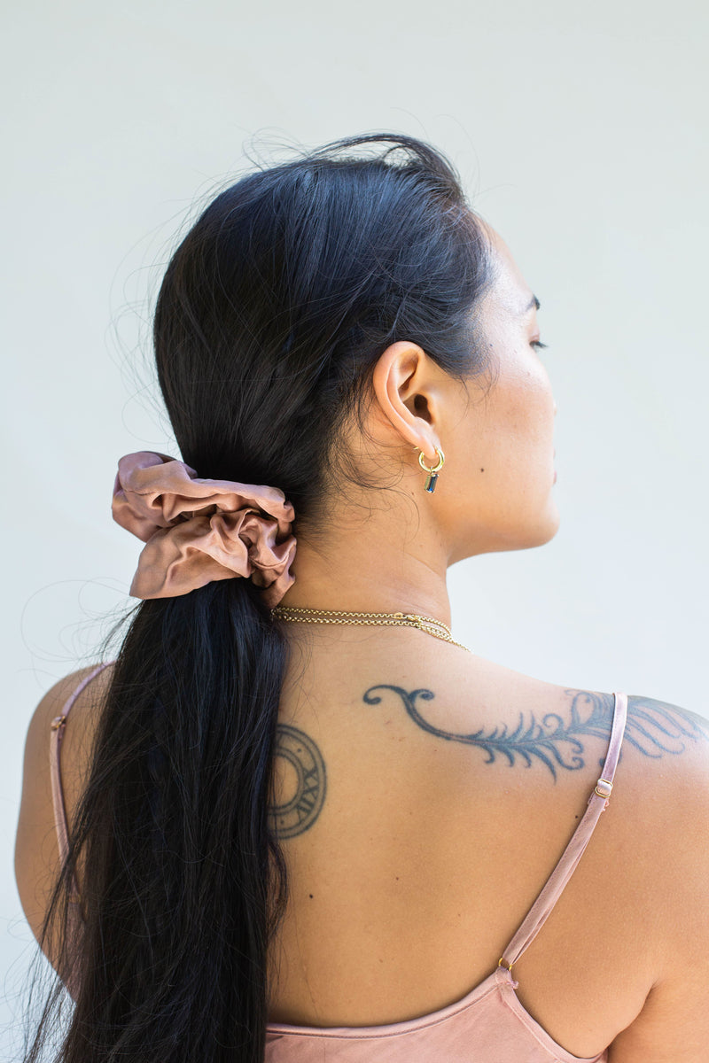 model wearing muted rose pink silk scrunchie in ponytail 