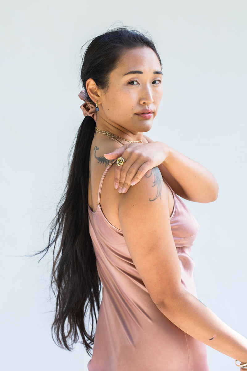 model looking back wearing muted rose pink silk scrunchie in ponytail 