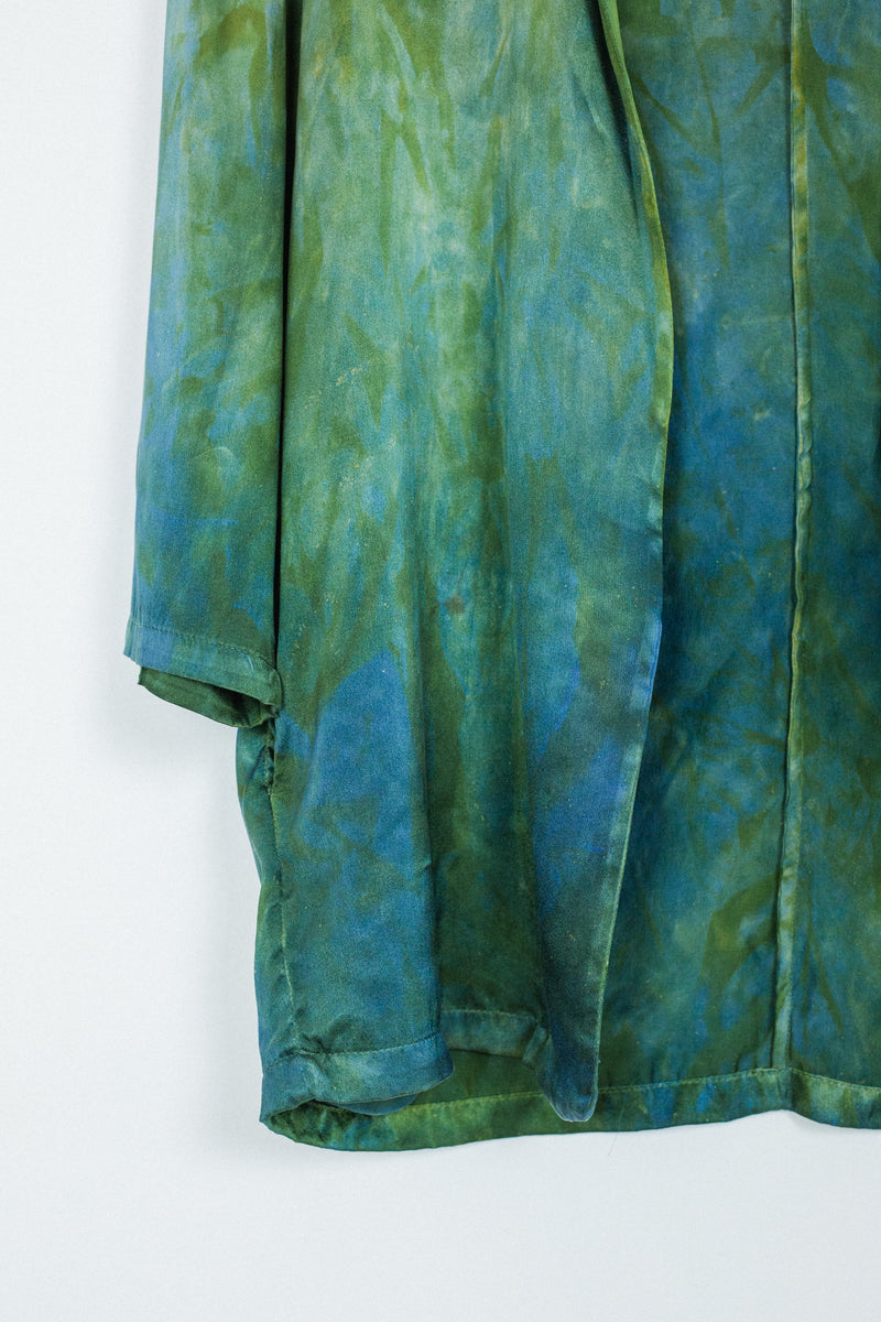 sleeve detail of silk blazer in hummingbird green blue color with unique markings