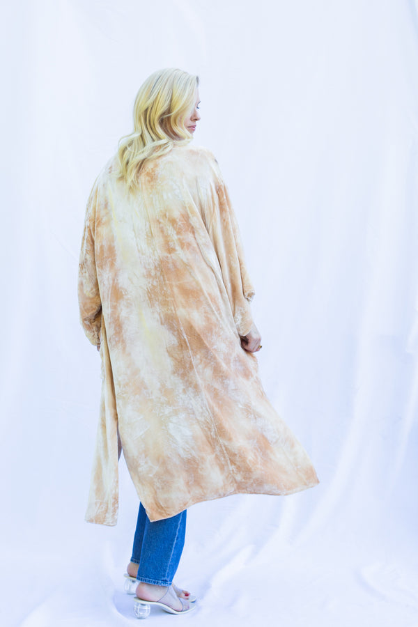 back view of women wearing velvet duster in marbled light color with peachy tones