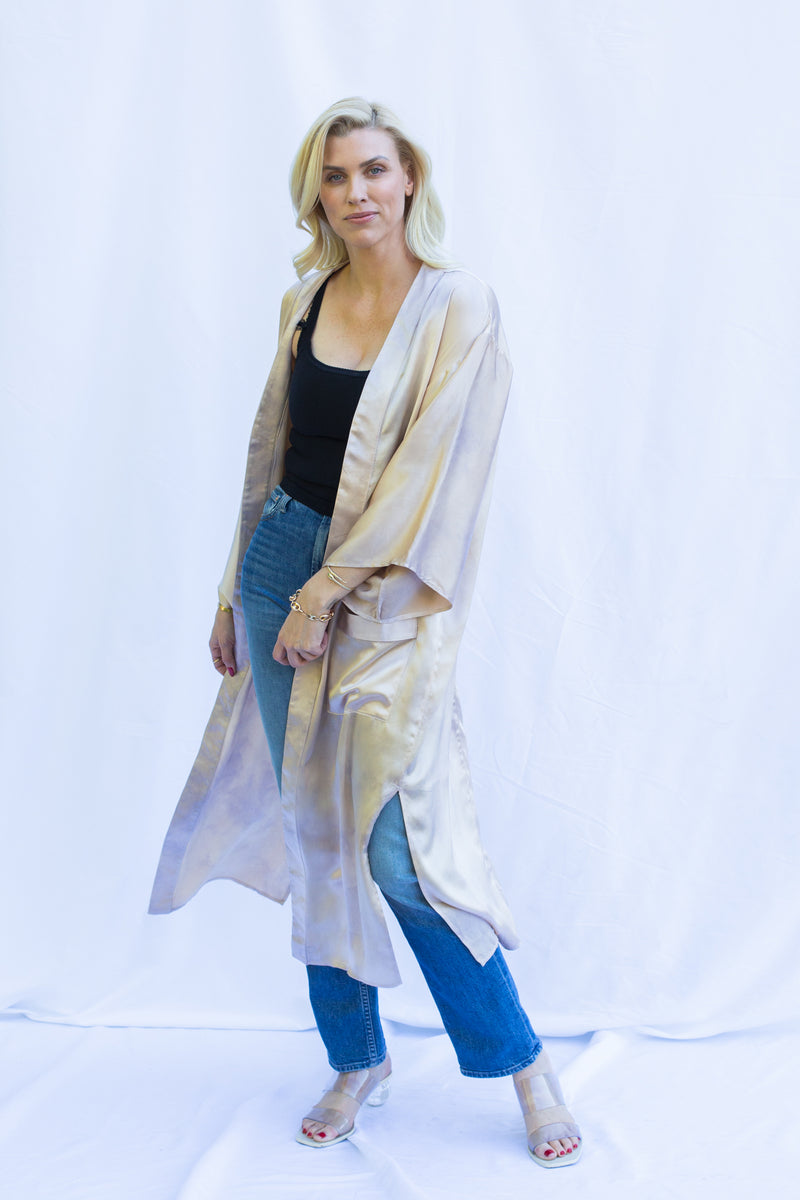 Blonde woman wearing silk duster in pearly pink.