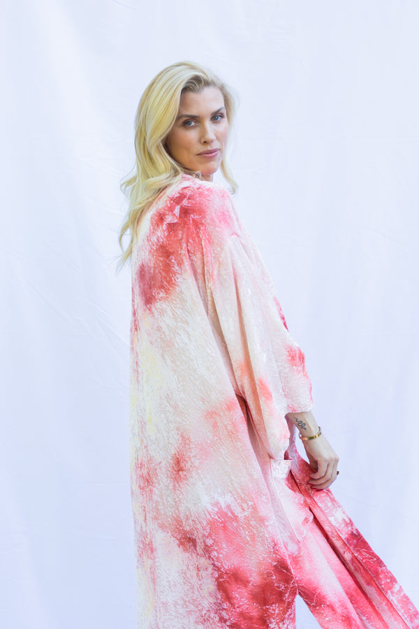 Side view of blond woman wearing velvet ceremony duster in heavenly pink color.