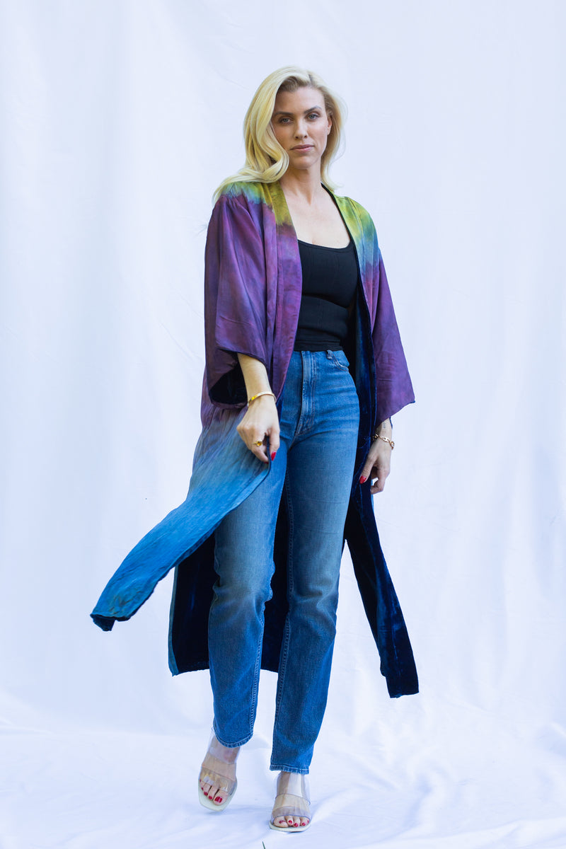 Woman wearing reverse silk side of velvet  duster in emerald night. It shows a gradient of green to purple to blue. 