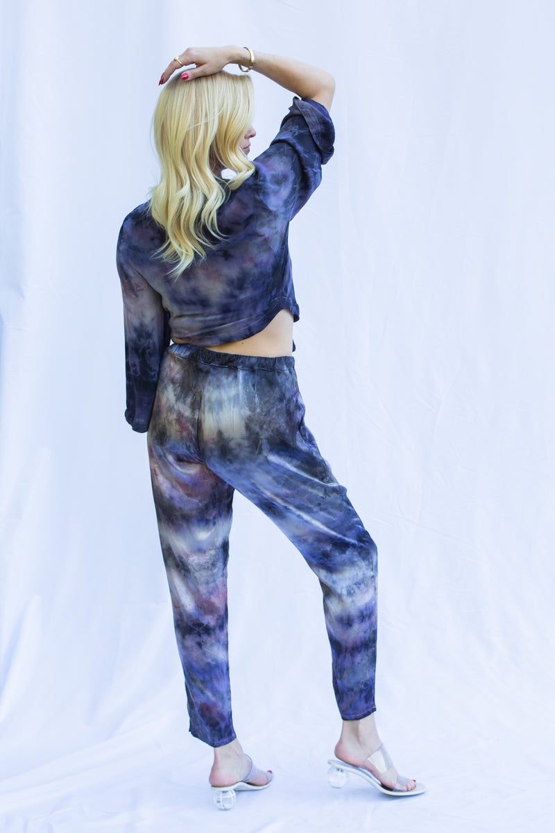 Back view of woman wearing wrap top in cosmica. Back has curved edge. 